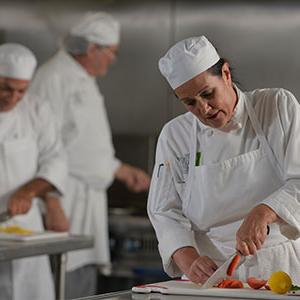 Female chef cutting vegetables