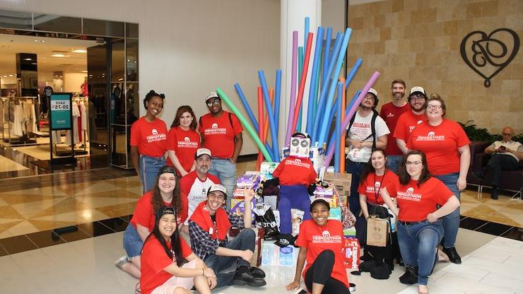 学生 of Montco's 戏剧艺术 program pose with the Iron Throne and "Tippie," both of which they created with donations for the Laurel House Works of heART community 项目. 马修·穆尔黑德摄